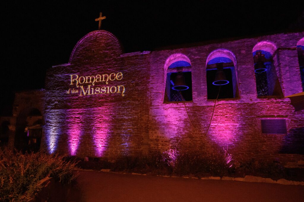 entrance of gala event lit up with pink lights and the name of the event