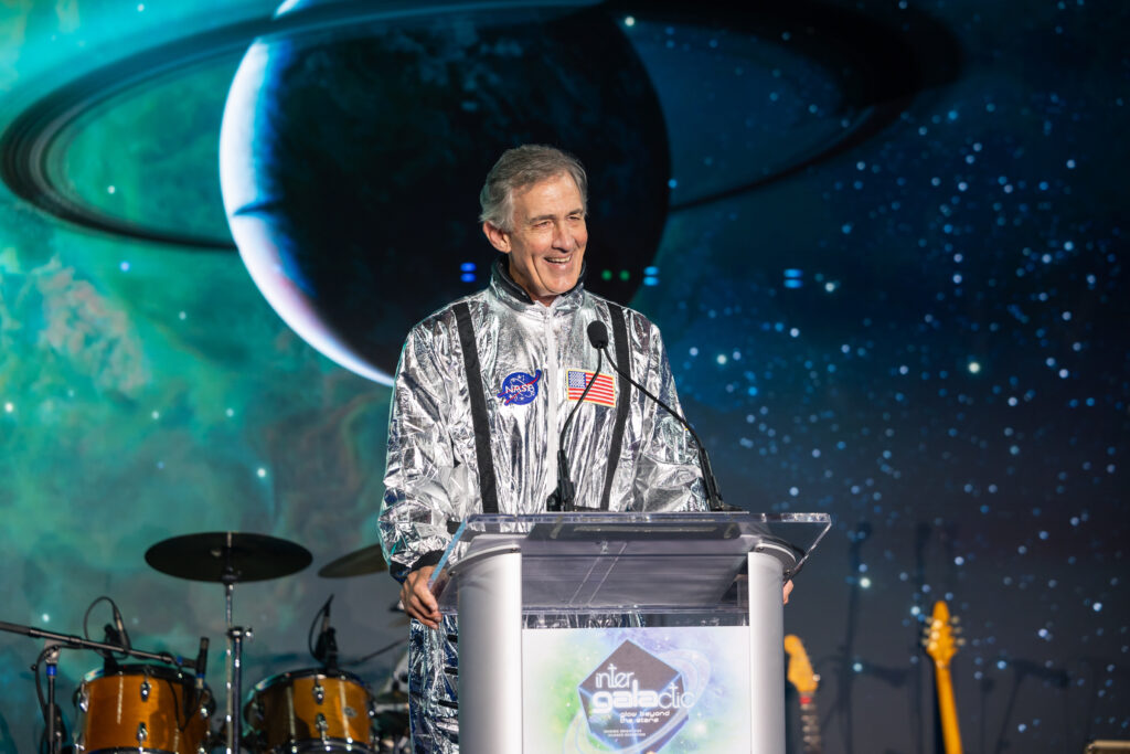 man in a space suit standing up on stage 