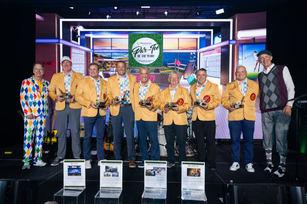 winners during charity gala standing up on stage with award of a golf club to fit with the event theme