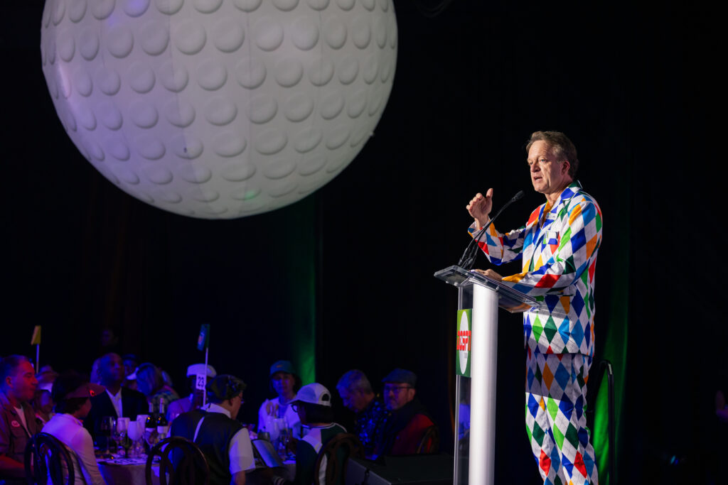 event speaker standing behind podium addressing the guests