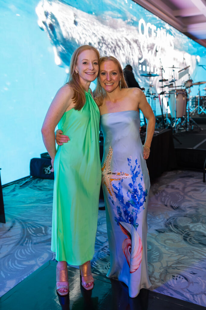 guests pose in front of large screen of sea life