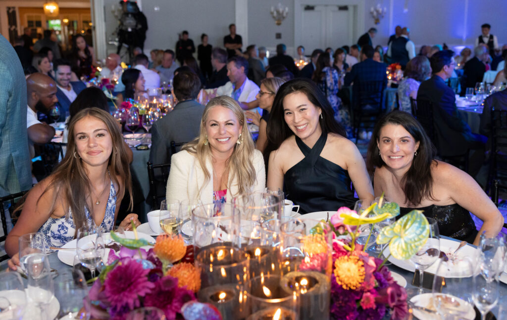 guests pose together while sitting at table