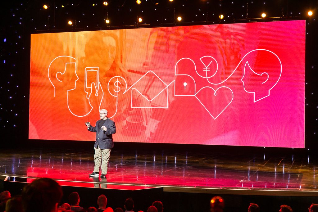 speaker speaks in front of LED screen on stage