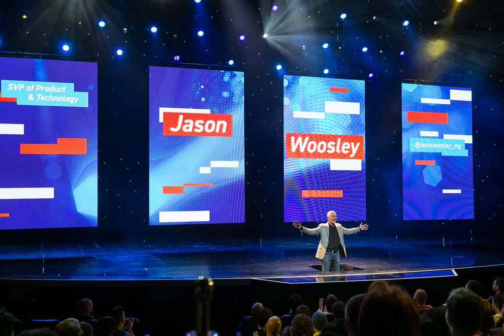 speaker stands in front of LED screens on stage