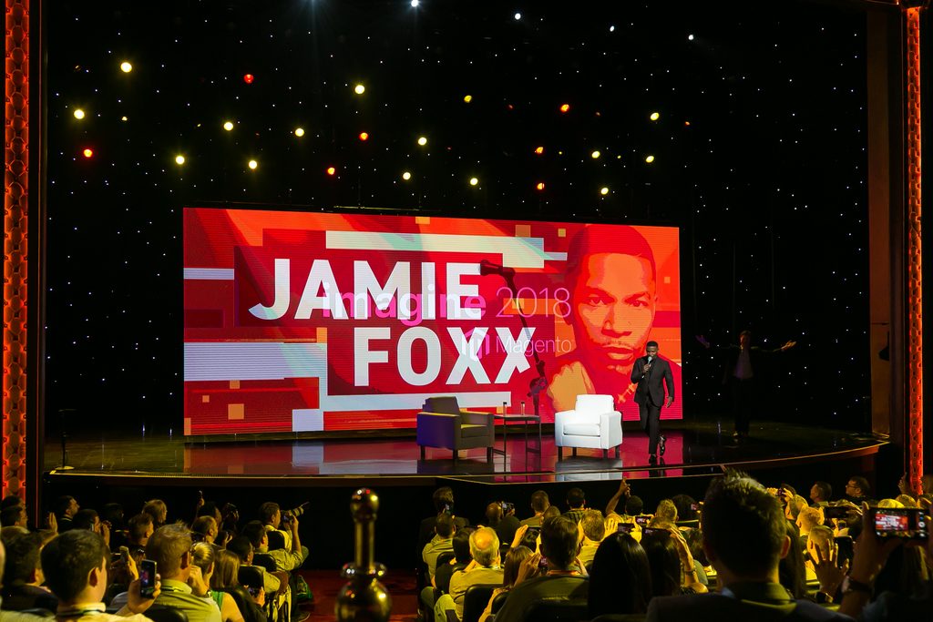 speaker speaks on stage in front of LED screen