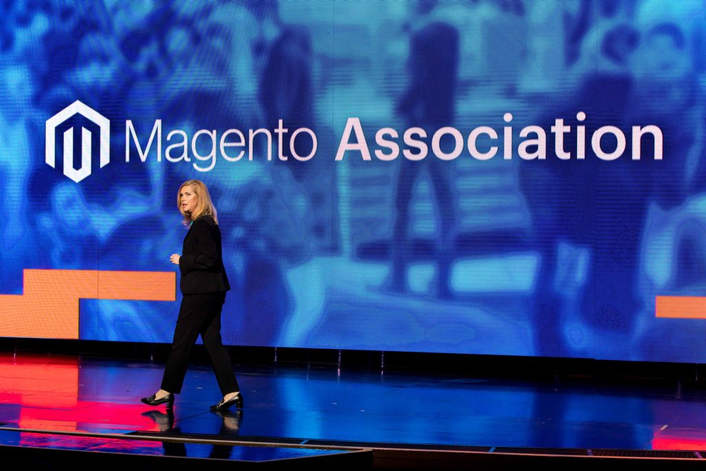 woman speaks on stage in front of LED screen