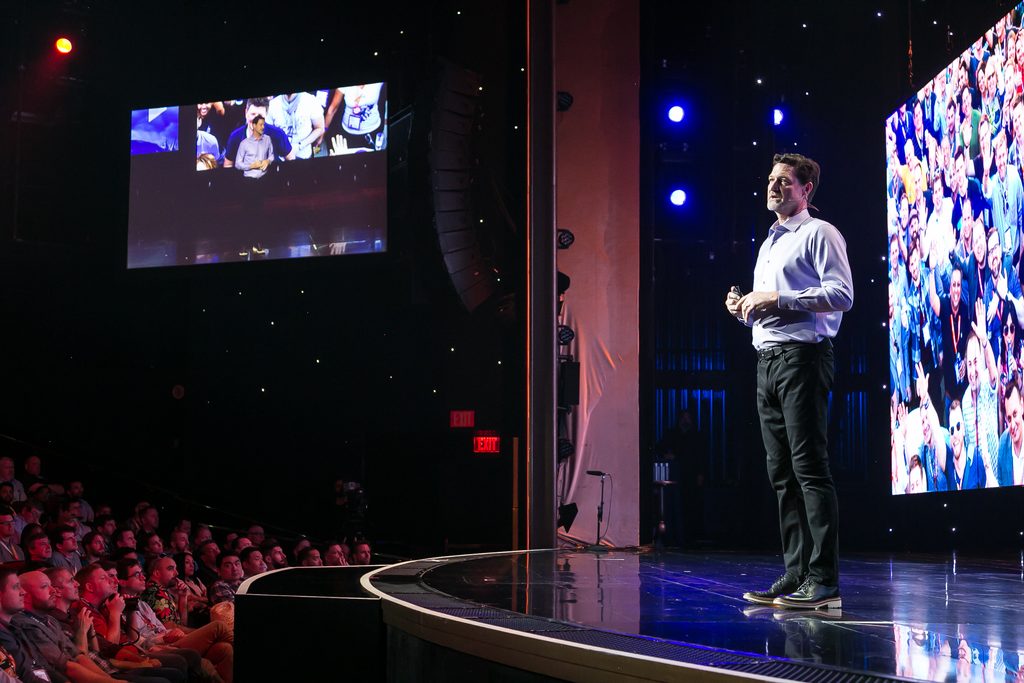 speakers speaks on stage in front of audience at ecommerce conference