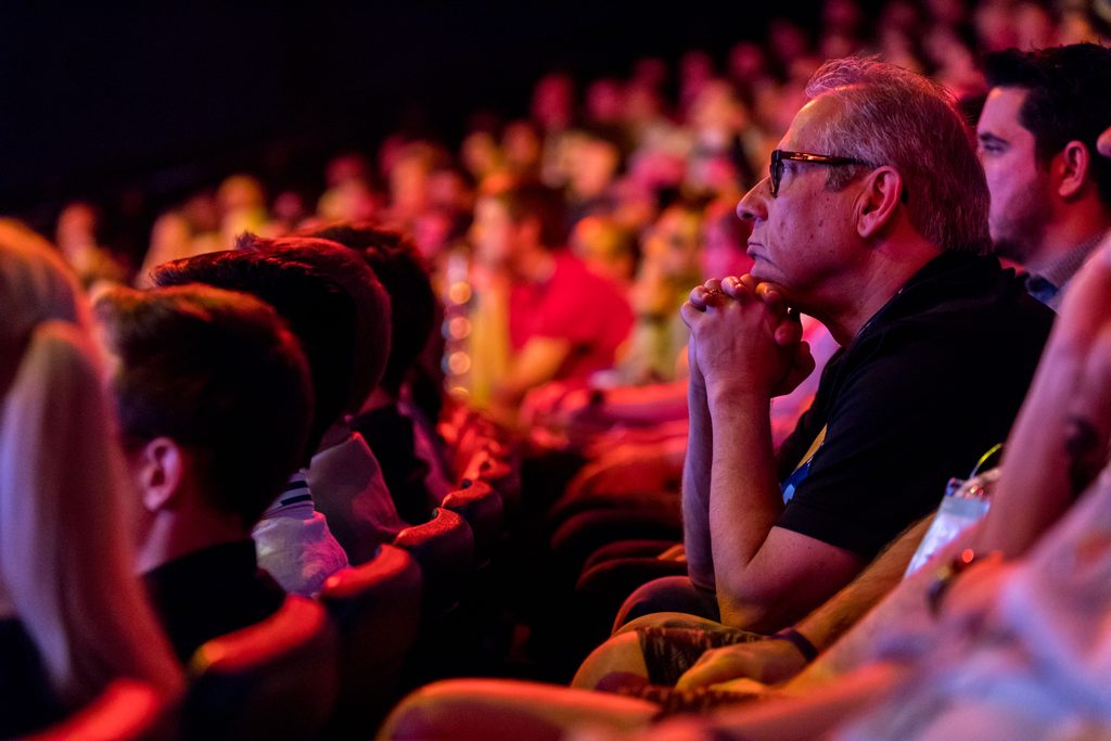 audience members listen while seated in an auditorium