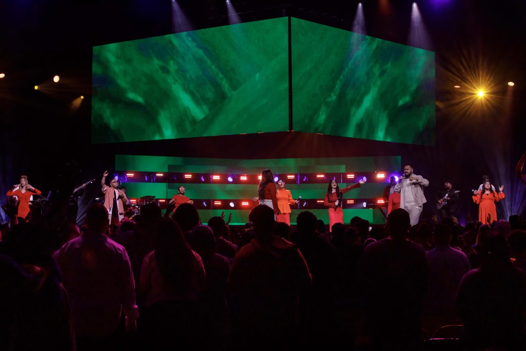 singers perform on stage with LED screen at live event