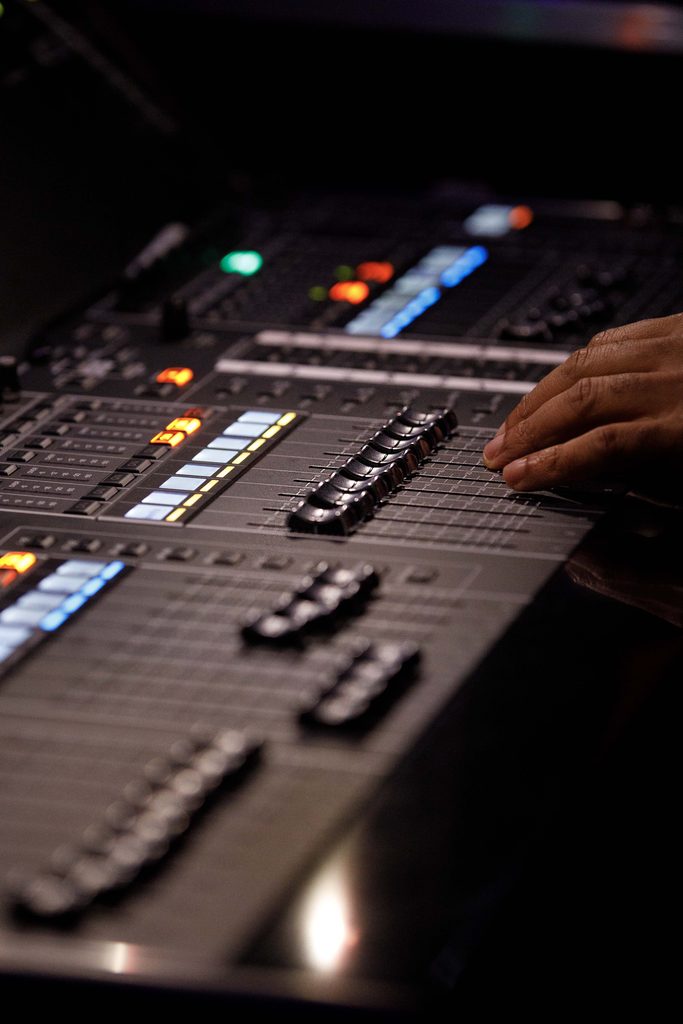 hand on buttons at sound board